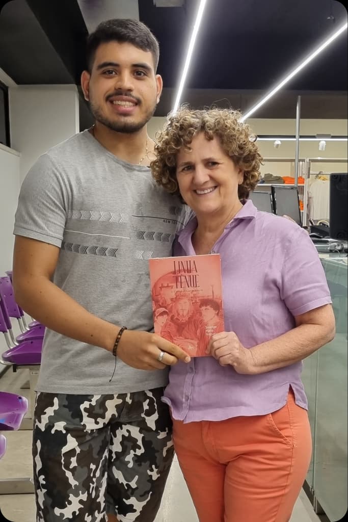Solange ao lado de um leitor que segura um exemplar de Linha Tênue