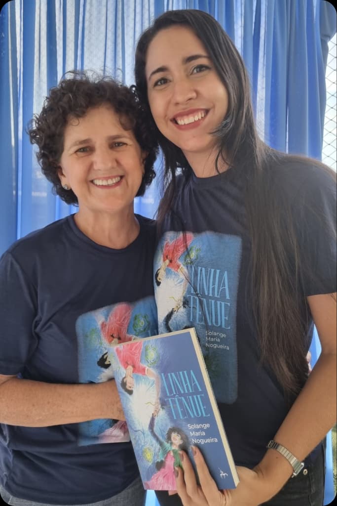 Solange ao lado de uma leitora que segura um exemplar de Linha Tênue