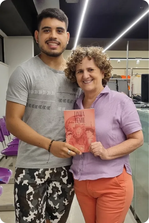 Solange ao lado de um leitor que segura um exemplar de Linha Tênue