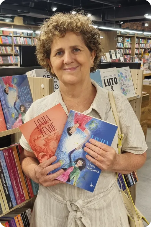 Solange Maria Nogueira segurando dois exemplares do romance Linha Tênue